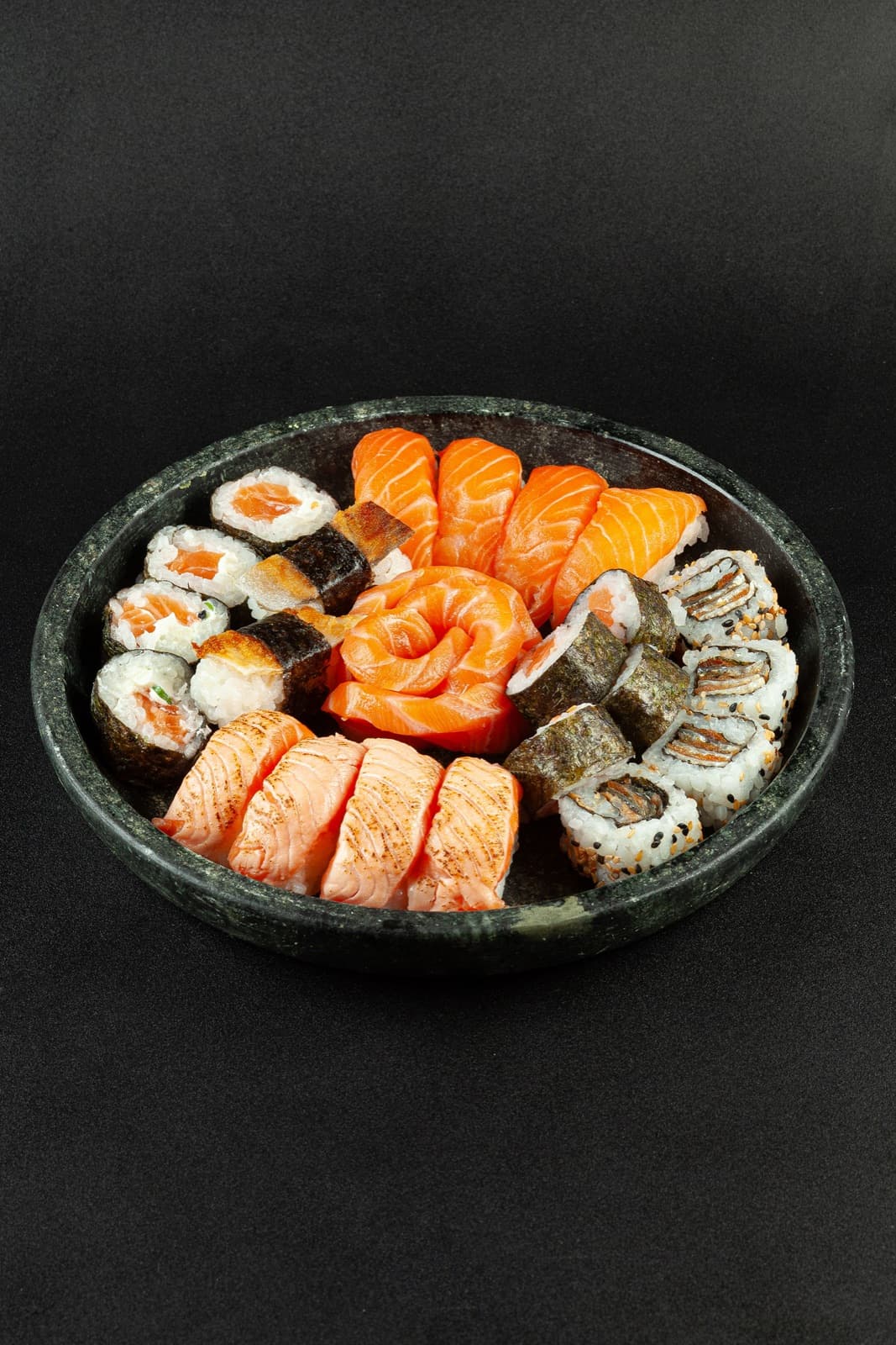 Bandeja de combinado de salmão com sashimis, uramakis, hossomakis e rosa de salmão ao centro