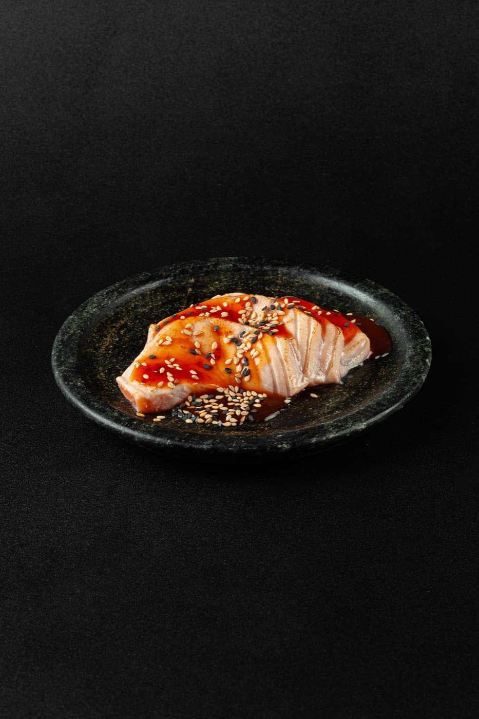 Sashimi Sakura: fatia de salmão selado e maçaricado com gergelim e molho