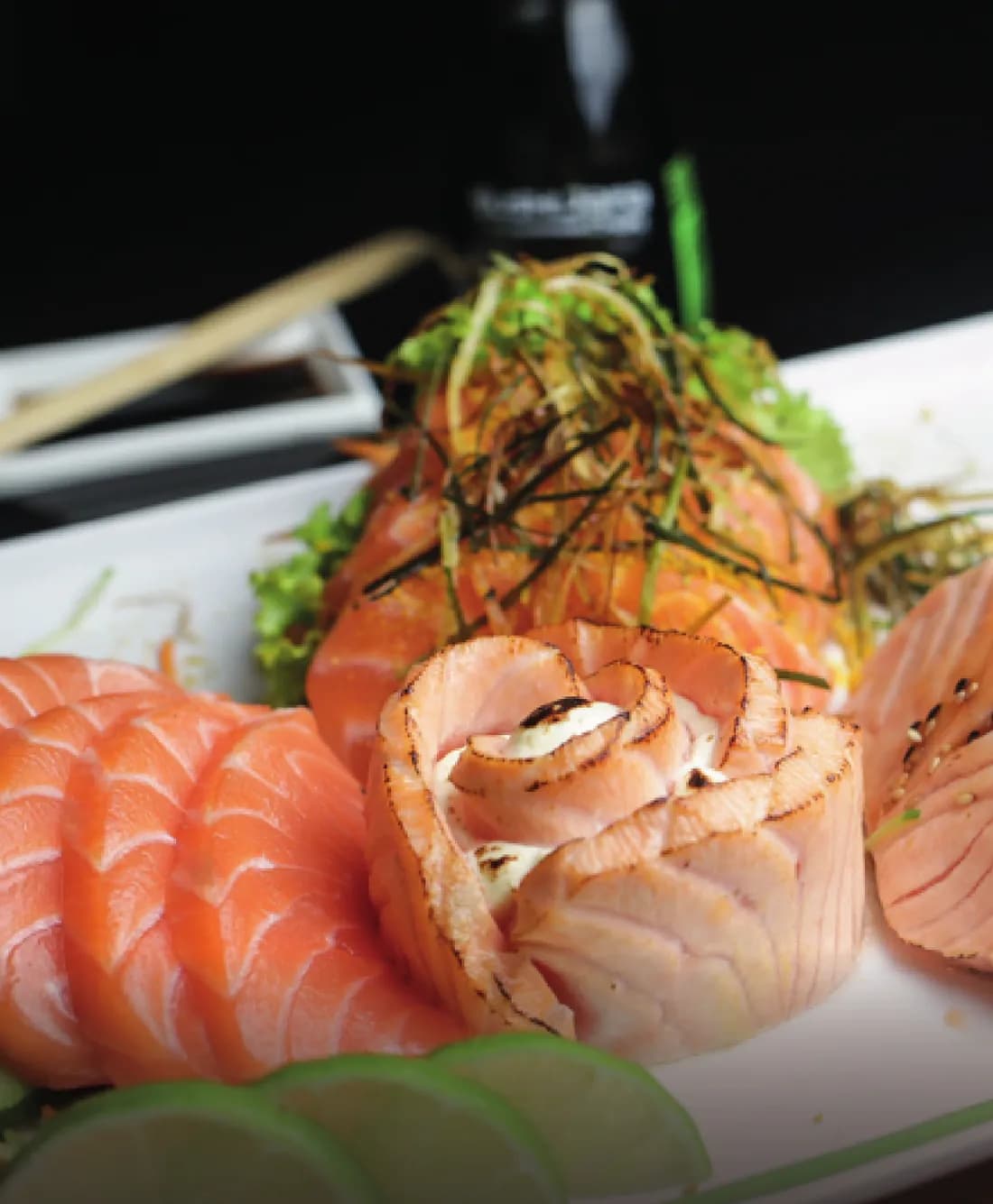 Sashimi de salmão com flor de salmão selado e fatias de limão