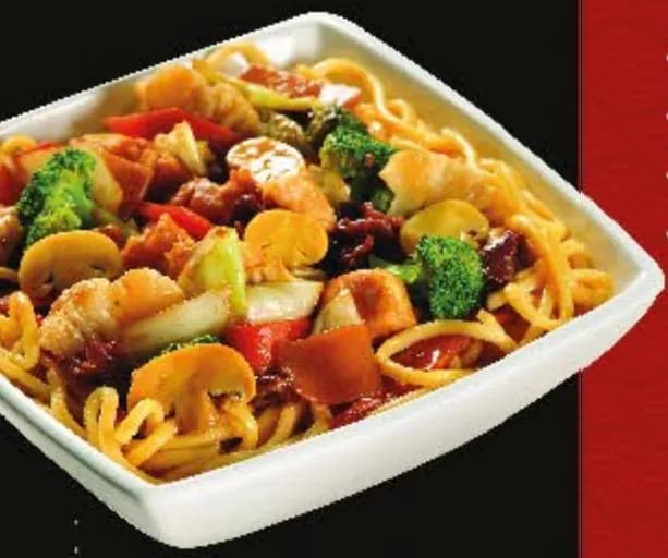 Yakissoba com legumes e cogumelos em travessa quadrada branca